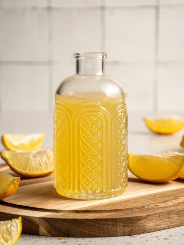 Jar with yellow colored lemon ginger shrub.