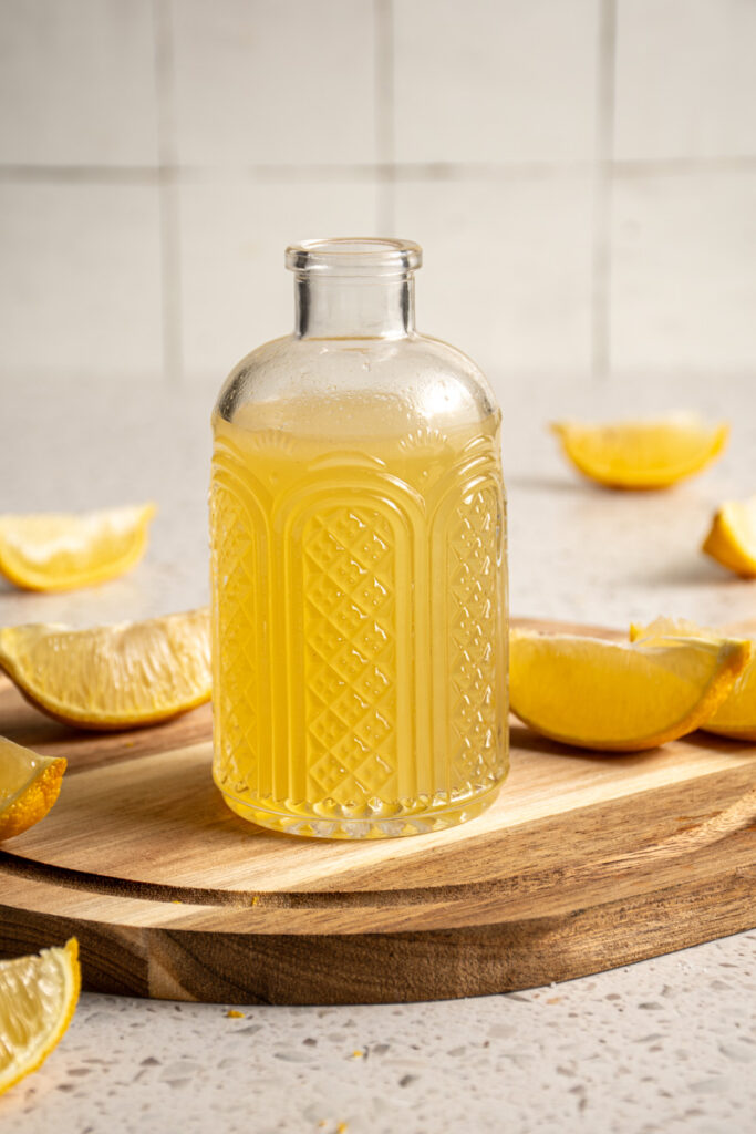 Jar with yellow colored lemon ginger shrub.