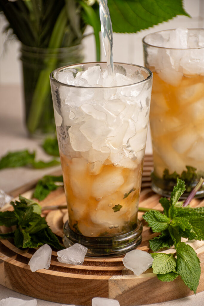 Pouring lemonade into the mocktail glass.