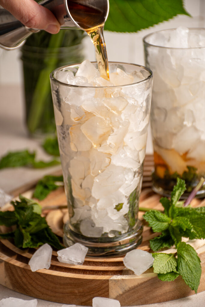 Pouring tea into an ice filled glass.